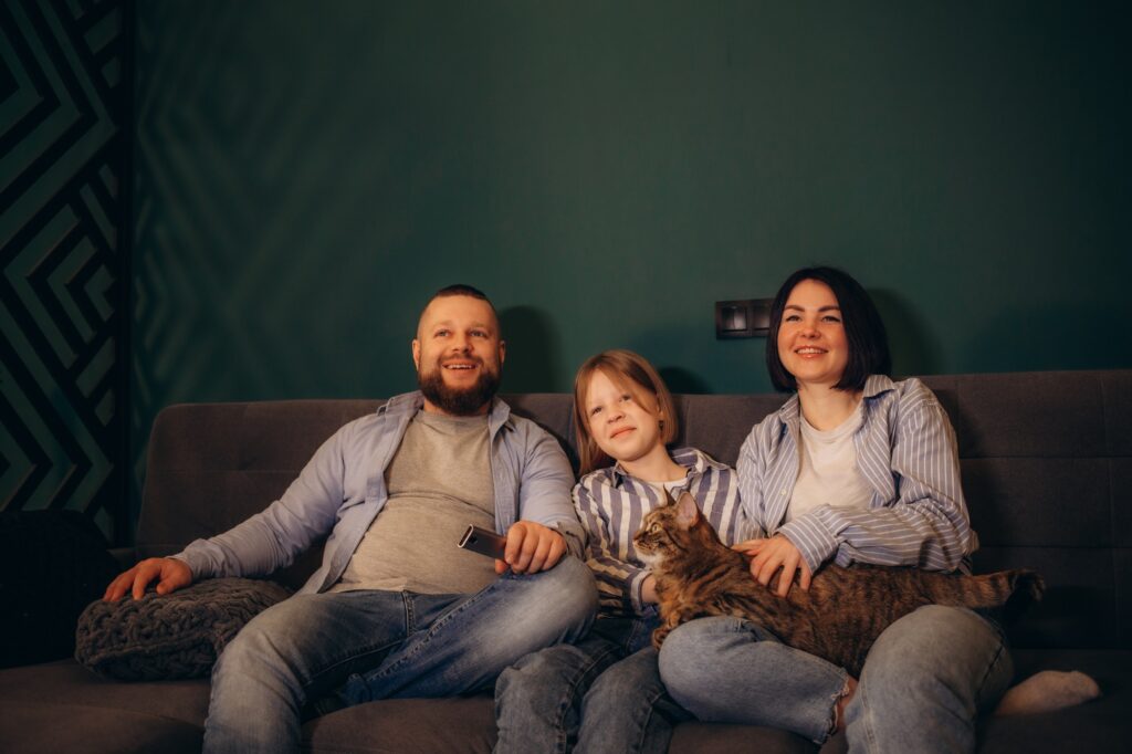 Family watching movie on sofa at night