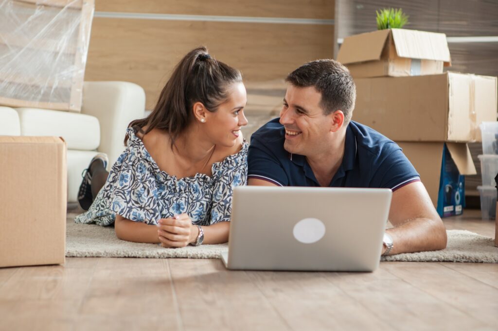 Young adults using their laptop in the new flat